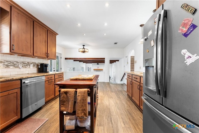 2106 Antelope Trl, Harker Heights, TX 76548 - kitchen featuring appliances with stainless steel finishes, light wood-type flooring, arched walkways, brown cabinetry, and recessed lighting