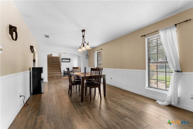 2106 Antelope Trl, Harker Heights, TX 76548 - dining area featuring a wainscoted wall, dark wood-style floors, arched walkways, and stairs