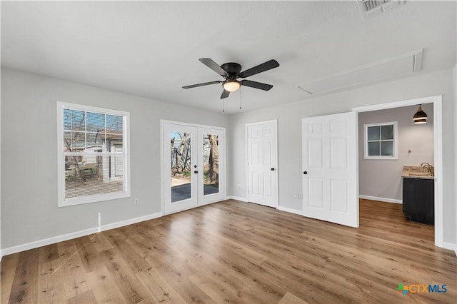 unfurnished bedroom featuring wood finished floors, visible vents, attic access, access to exterior, and french doors