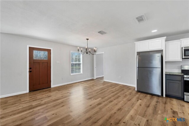 kitchen with light wood-style flooring, visible vents, and stainless steel appliances