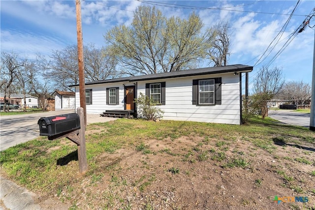 single story home featuring a garage, driveway, and an outdoor structure