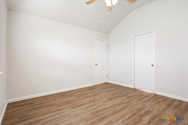 unfurnished bedroom featuring baseboards, vaulted ceiling, and light wood-style floors