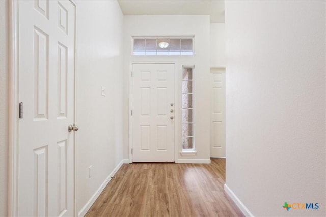 foyer entrance with light wood finished floors and baseboards