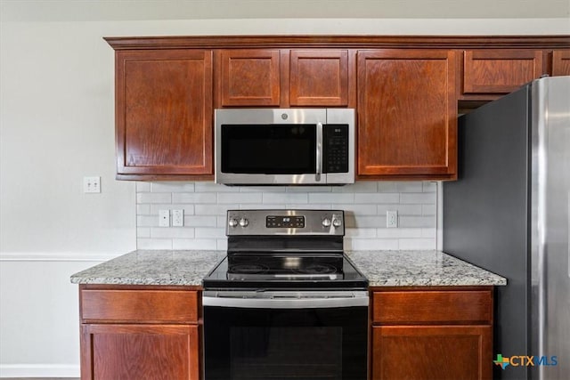 kitchen with decorative backsplash, stainless steel appliances, and light stone counters