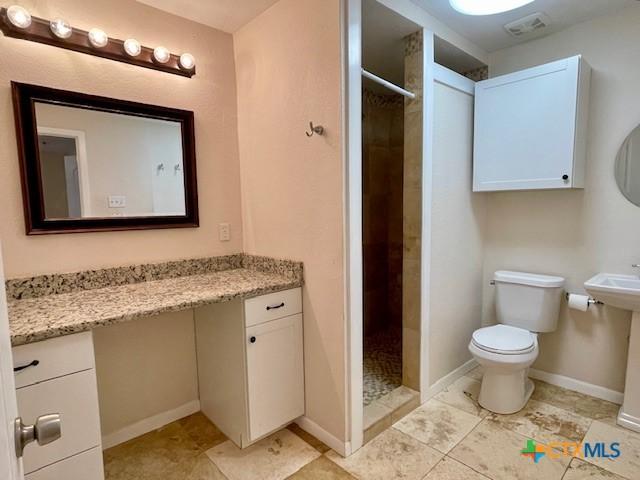 1541 Cologne Dr, New Braunfels, TX 78130 - full bathroom with toilet, visible vents, tile patterned flooring, a shower stall, and baseboards