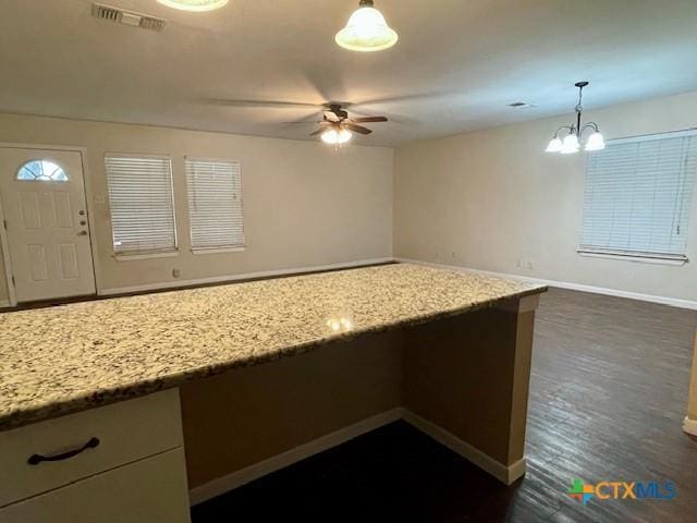 1541 Cologne Dr, New Braunfels, TX 78130 - kitchen featuring ceiling fan with notable chandelier, visible vents, light stone countertops, hanging light fixtures, and baseboards