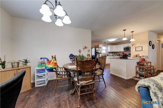 dining area featuring dark wood-style flooring, baseboards, and an inviting chandelier