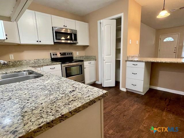 1541 Cologne Dr, New Braunfels, TX 78130 - kitchen with a sink, stainless steel appliances, white cabinets, visible vents, and light stone countertops