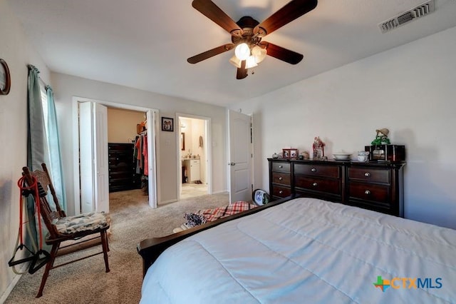 carpeted bedroom featuring visible vents, connected bathroom, a ceiling fan, a spacious closet, and a closet