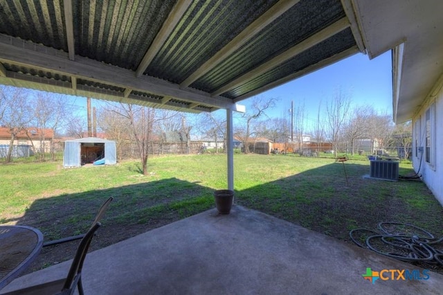 view of yard with a patio area, a fenced backyard, an outdoor structure, and central air condition unit