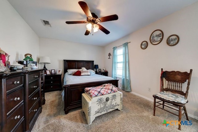 bedroom with light carpet, a ceiling fan, visible vents, and baseboards