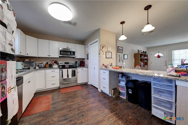 kitchen with stainless steel appliances, light stone counters, dark wood finished floors, and white cabinets