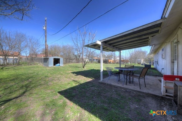 view of yard featuring an outbuilding, a storage unit, a patio area, and a fenced backyard