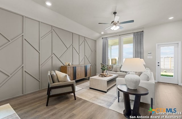 sitting room with ceiling fan, lofted ceiling, and light wood-type flooring