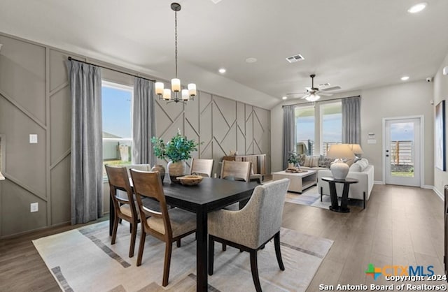 dining room with vaulted ceiling, plenty of natural light, and hardwood / wood-style floors