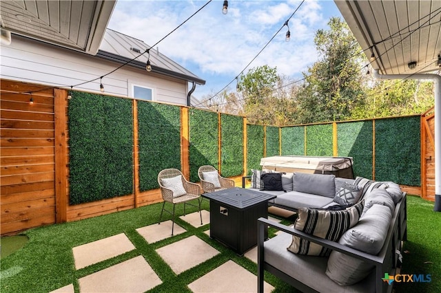 view of patio featuring a hot tub and an outdoor living space with a fire pit