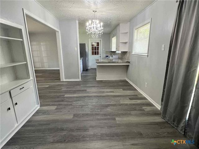 1818 Travis Ave, Victoria, TX 77901 - kitchen featuring open shelves, a textured ceiling, a chandelier, white cabinets, and dark wood-style flooring