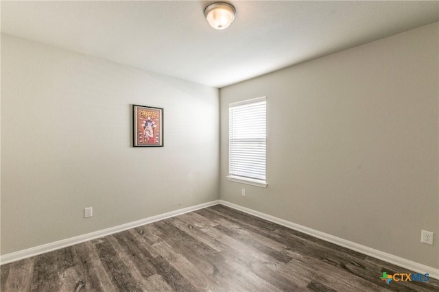 unfurnished room with dark wood-type flooring