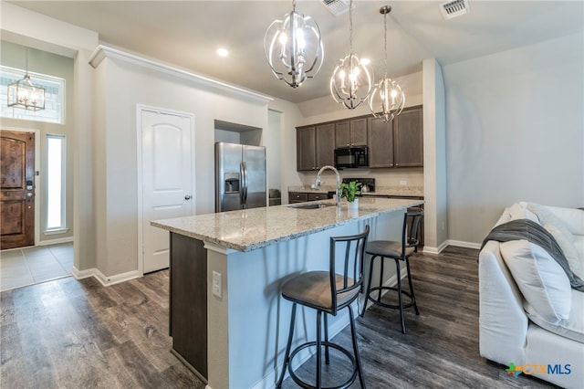 kitchen with stainless steel fridge with ice dispenser, dark brown cabinetry, sink, dark wood-type flooring, and a kitchen island with sink