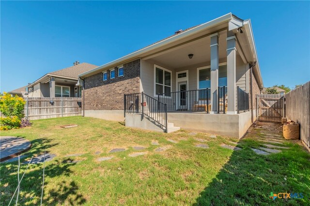 rear view of property featuring a lawn