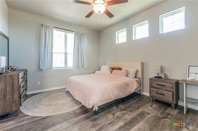 bedroom with dark wood-type flooring, multiple windows, and ceiling fan