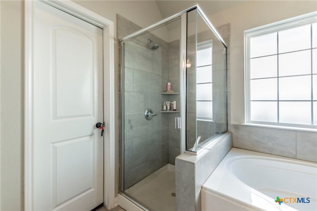 bathroom featuring a wealth of natural light and separate shower and tub