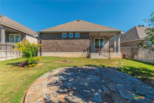 back of property featuring a lawn and a patio