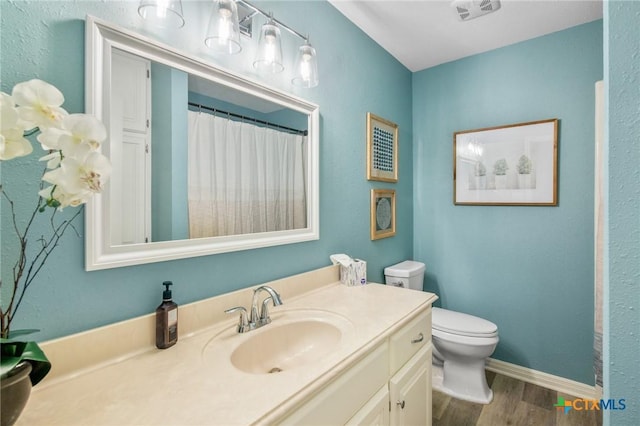 119 Larimore St, Victoria, TX 77904 - bathroom featuring wood finished floors, toilet, vanity, and baseboards