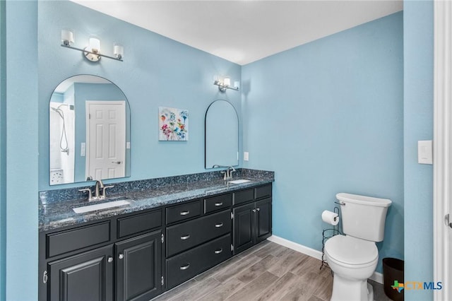 119 Larimore St, Victoria, TX 77904 - full bathroom with double vanity, toilet, wood finished floors, and baseboards