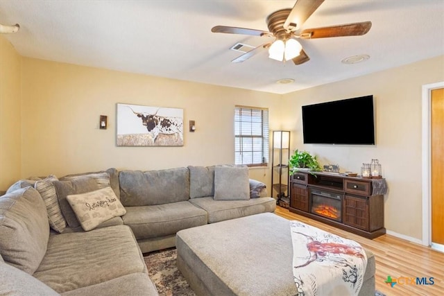 living room featuring ceiling fan and light wood-type flooring