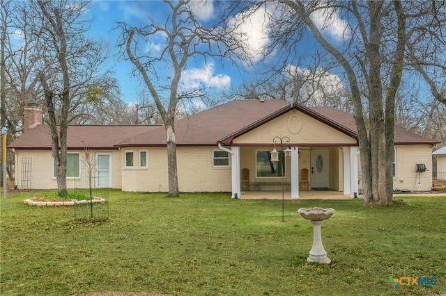 rear view of property with a yard and a patio