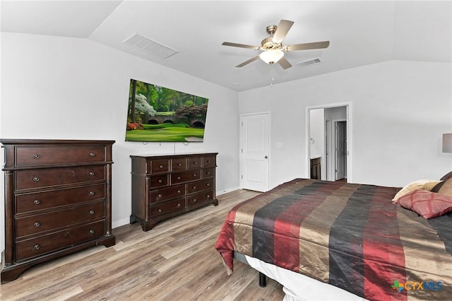 bedroom featuring ceiling fan, lofted ceiling, ensuite bathroom, and light hardwood / wood-style flooring