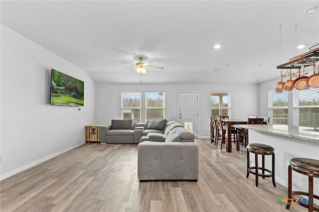 living room with light hardwood / wood-style flooring and ceiling fan