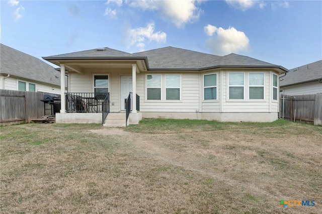 rear view of property featuring a yard