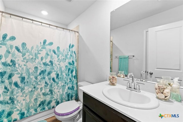 bathroom featuring walk in shower, vanity, and toilet