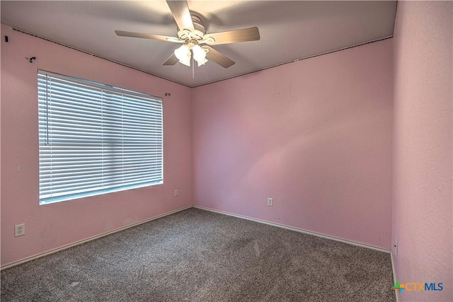 empty room featuring ceiling fan and carpet