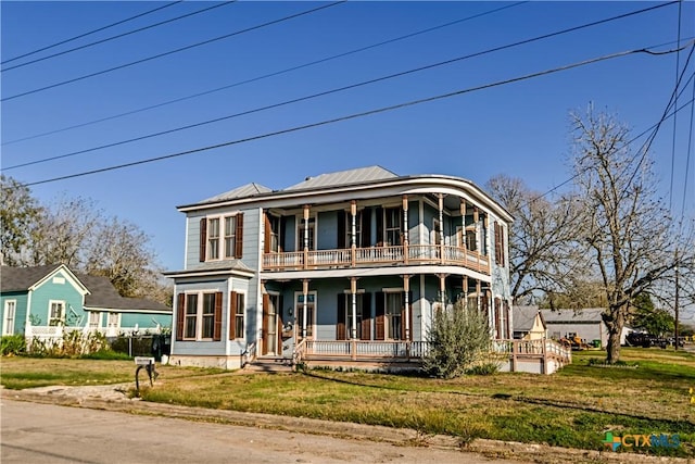 view of front of home featuring a balcony and a front lawn