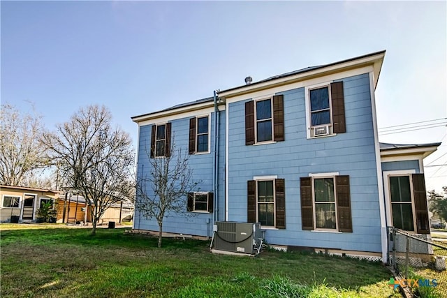 rear view of property featuring a yard and central AC