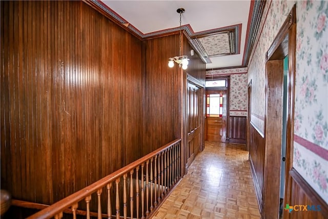 hallway featuring light parquet flooring, a chandelier, and ornamental molding