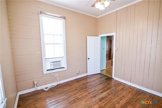 unfurnished room featuring wood walls, dark wood-type flooring, cooling unit, crown molding, and ceiling fan