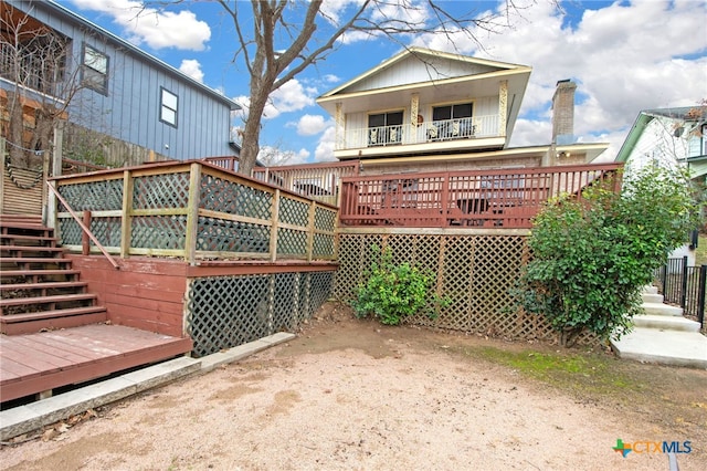 rear view of property featuring a wooden deck