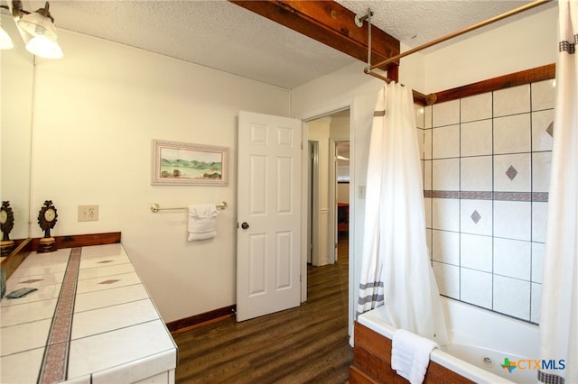 bathroom featuring shower / bath combo, wood-type flooring, and a textured ceiling