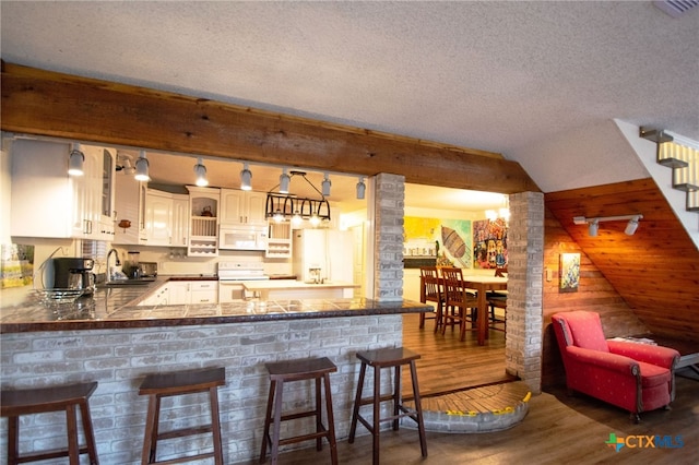 bar with dark hardwood / wood-style floors, decorative light fixtures, sink, white cabinets, and white appliances