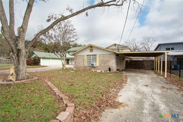 view of front of house with a carport, a garage, and a front lawn