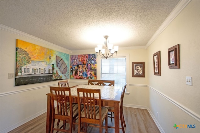 dining area featuring ornamental molding, a chandelier, hardwood / wood-style floors, and a textured ceiling