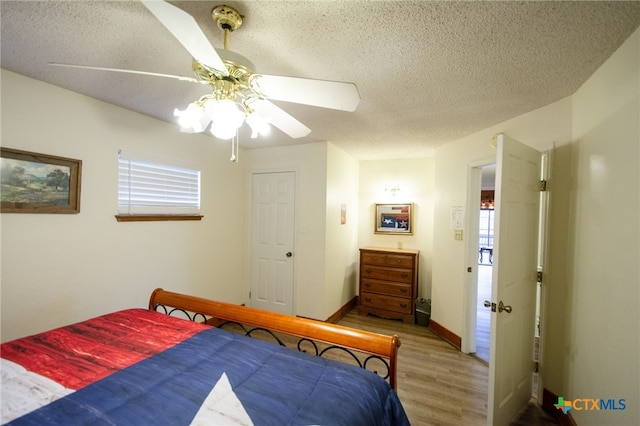 bedroom with multiple windows, wood-type flooring, ceiling fan, and a textured ceiling