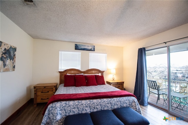 bedroom featuring dark hardwood / wood-style flooring, access to exterior, and a textured ceiling