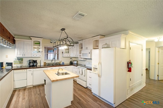 kitchen featuring sink, white cabinetry, decorative light fixtures, a center island, and white appliances