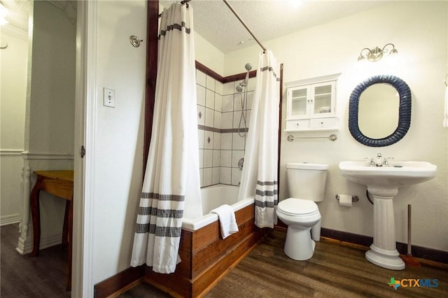 bathroom featuring wood-type flooring, shower / tub combo, a textured ceiling, and toilet