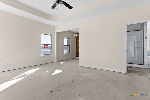 empty room featuring ceiling fan with notable chandelier